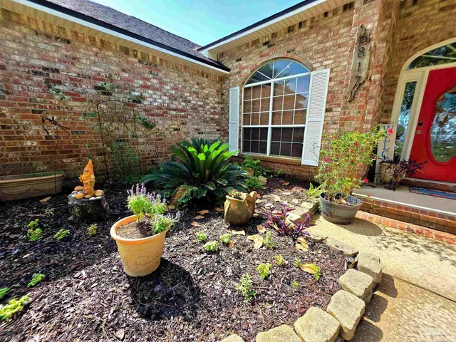 a front view of a house with a garden and yard