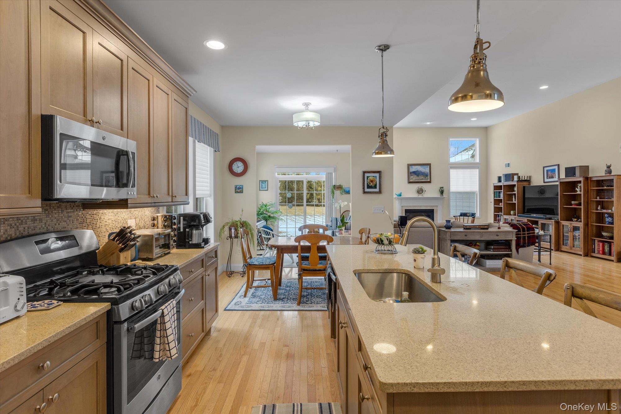 390 Stonecrop Road Riverhead, NY 11901 - Photo 24 of 24 a kitchen with stainless steel appliances granite countertop a stove top oven a sink dishwasher a dining table and chairs with wooden floor