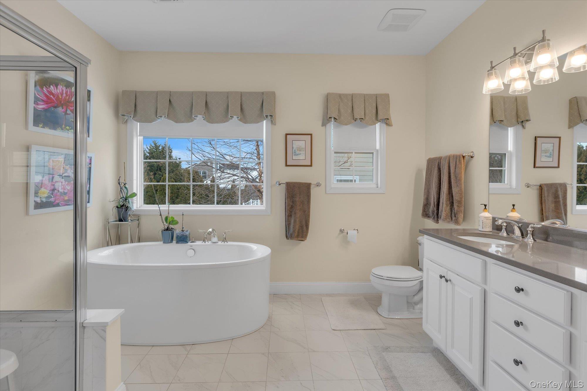 390 Stonecrop Road Riverhead, NY 11901 - Photo 14 of 24 a spacious bathroom with a sink a toilet and a large mirror