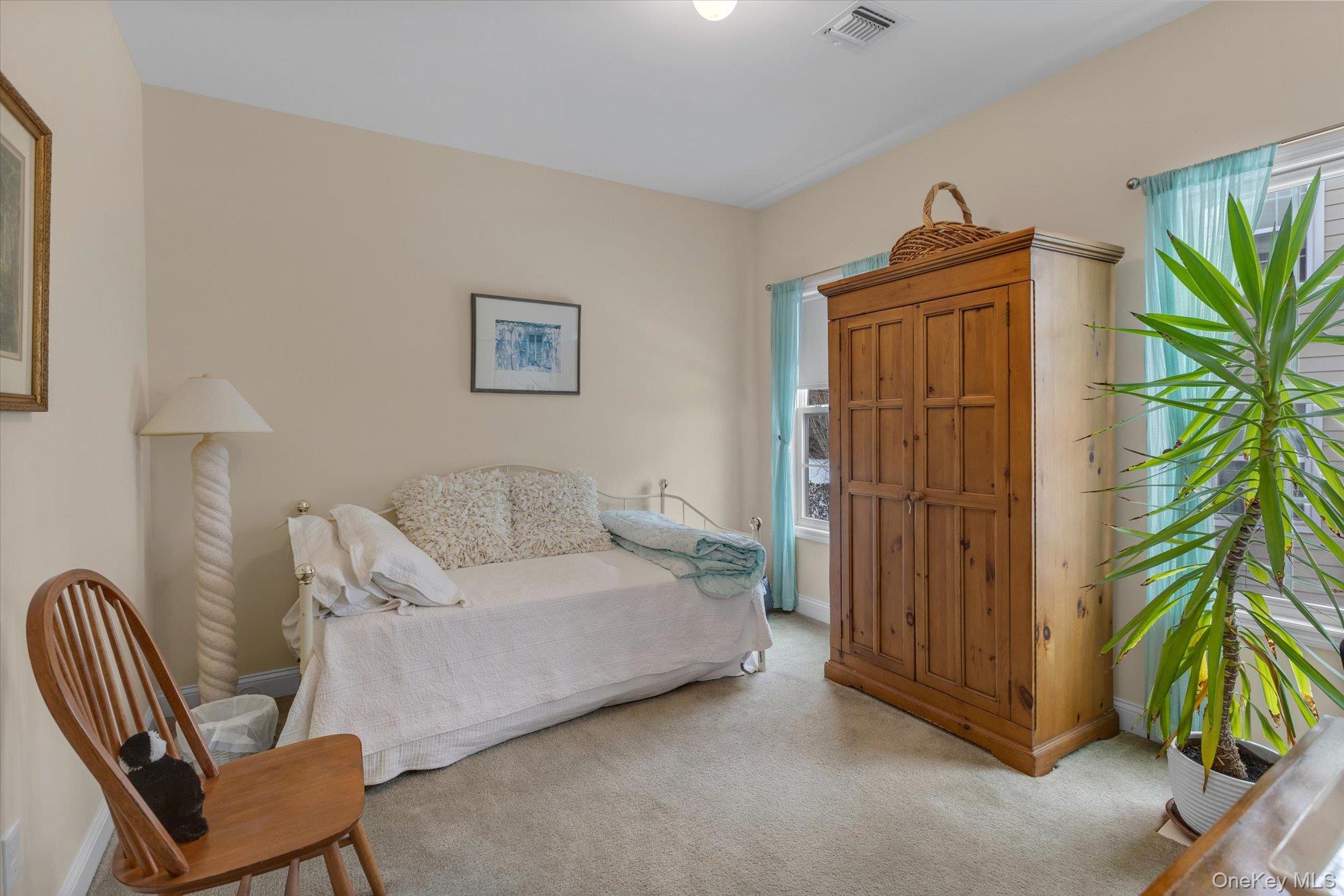 390 Stonecrop Road Riverhead, NY 11901 - Photo 18 of 24 a bedroom with furniture and a potted plant