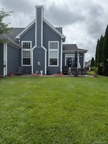 a backyard of a house with table and chairs