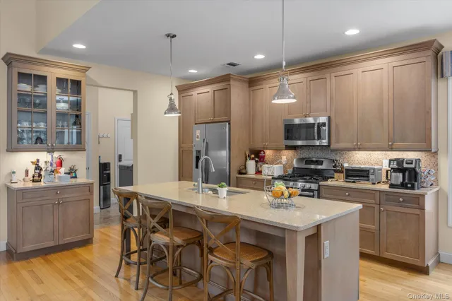 a kitchen that has a lot of cabinets a sink and appliances in it