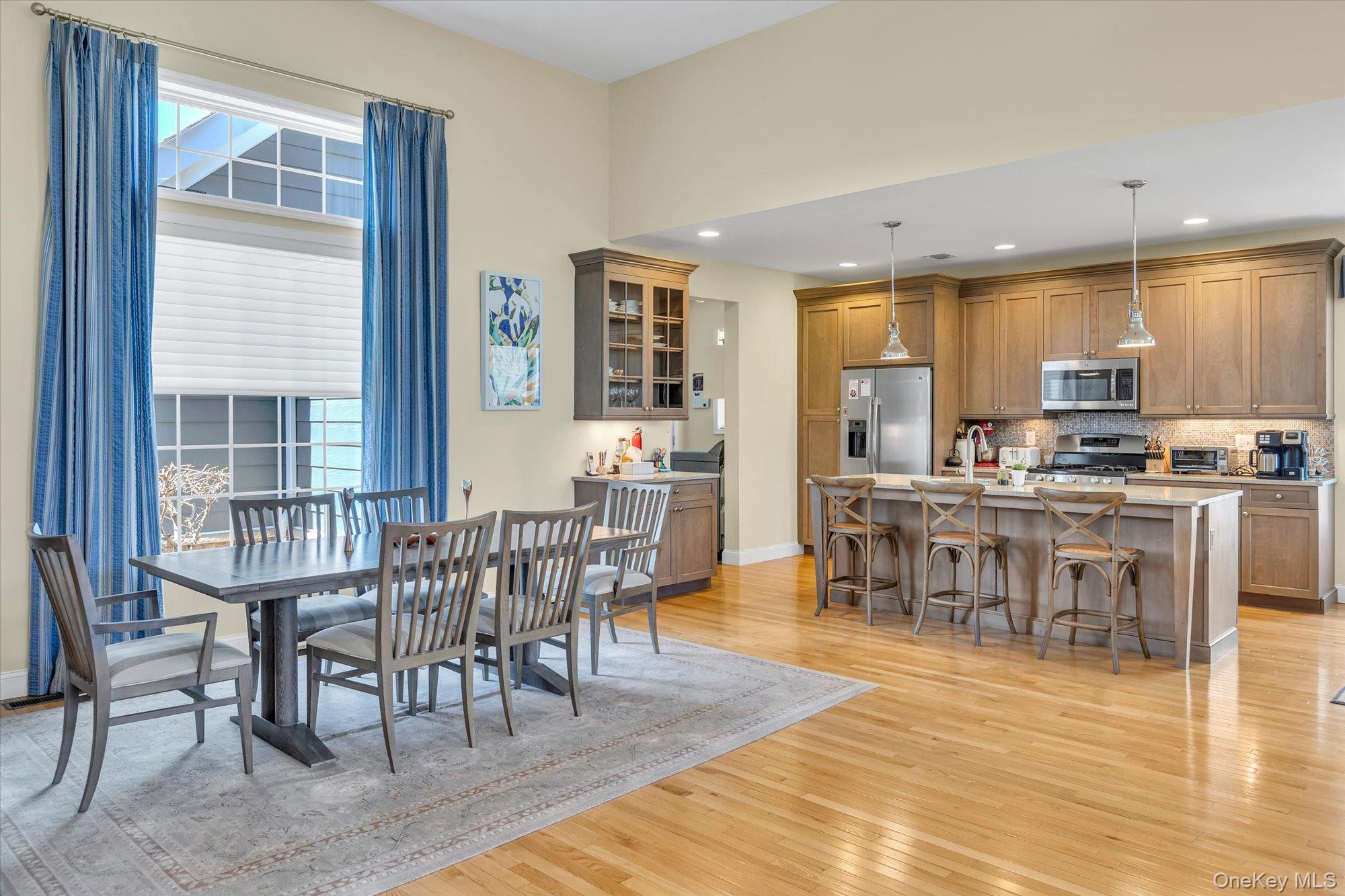 390 Stonecrop Road Riverhead, NY 11901 - Photo 7 of 24 a open kitchen with stainless steel appliances granite countertop a dining table chairs stove a sink and dishwasher a refrigerator with wooden floor