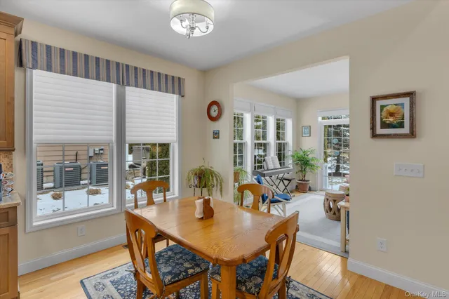 a kitchen with stainless steel appliances granite countertop a stove top oven a sink dishwasher a dining table and chairs with wooden floor