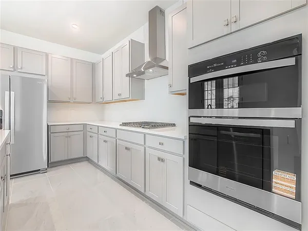 a kitchen with cabinets stainless steel appliances and sink