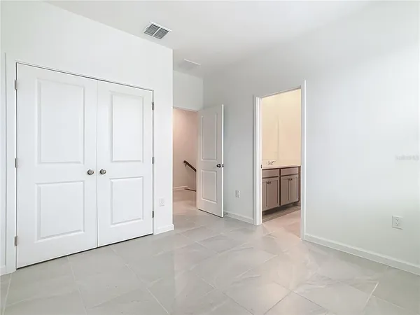 a view of a kitchen with refrigerator and white cabinets