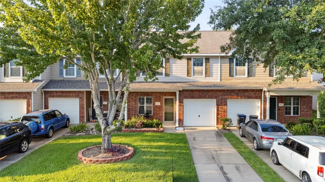 a front view of a house with a yard fire pit and a large tree