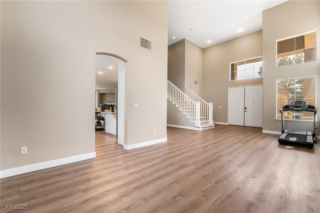 2392 Rainswept Avenue Henderson, NV 89052 - Photo 10 of 49 Foyer entrance with stairs, arched walkways, a towering ceiling, baseboards, and visible vents