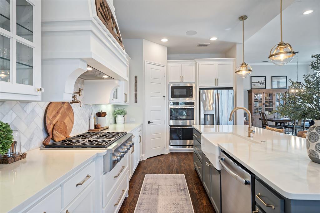 16509 Prairie Oak Road Frisco, TX 75033 - Photo 13 of 39 a kitchen with kitchen island granite countertop a stove a sink and a refrigerator