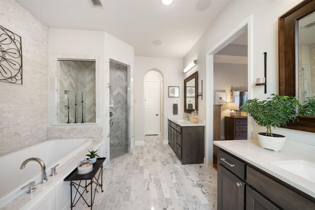16509 Prairie Oak Road Frisco, TX 75033 - Photo 18 of 39 a spacious bathroom with a granite countertop sink a mirror a vanity and shower
