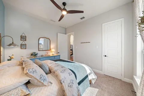 a bedroom with a large bed and ceiling fan