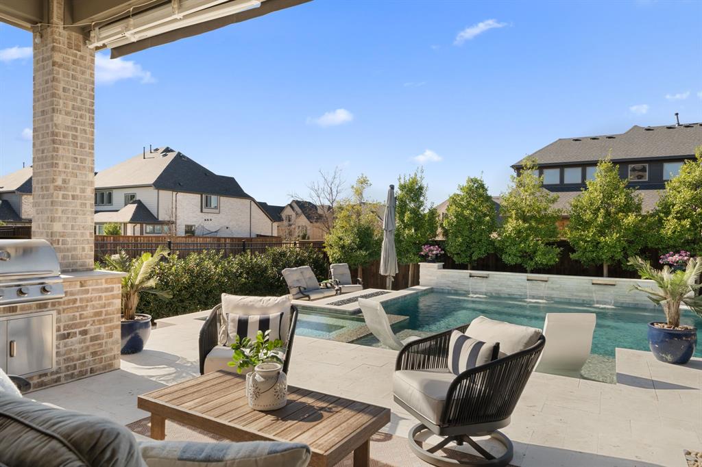 16509 Prairie Oak Road Frisco, TX 75033 - Photo 30 of 39 a view of a patio with couches table and chairs under an umbrella with a fire pit