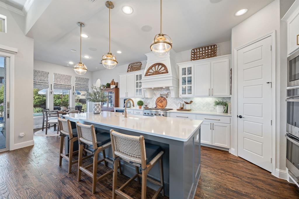 16509 Prairie Oak Road Frisco, TX 75033 - Photo 3 of 39 a kitchen with center island table and chairs in it