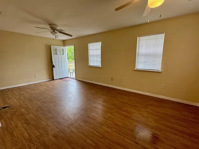 a view of empty room with wooden floor