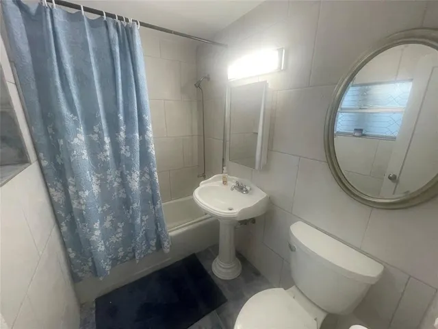 a bathroom with a sink toilet and a mirror
