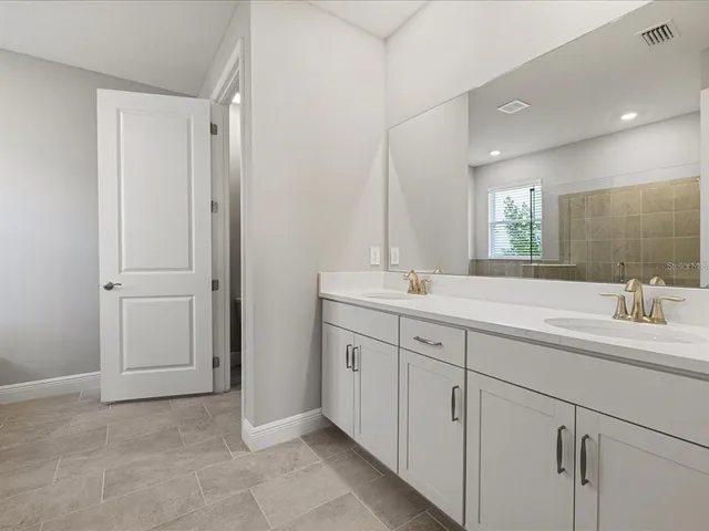 a bathroom with a double vanity sink and a mirror