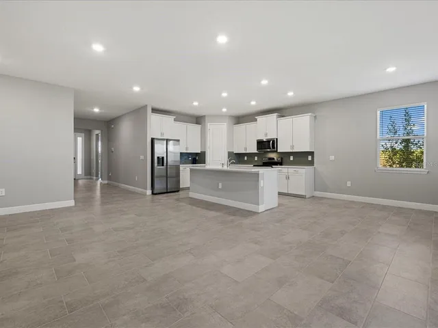 a view of kitchen with refrigerator and windows