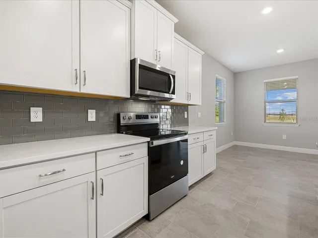 a kitchen with stainless steel appliances white cabinets and a sink