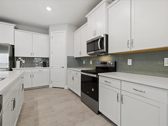 a kitchen with white cabinets stainless steel appliances and a sink