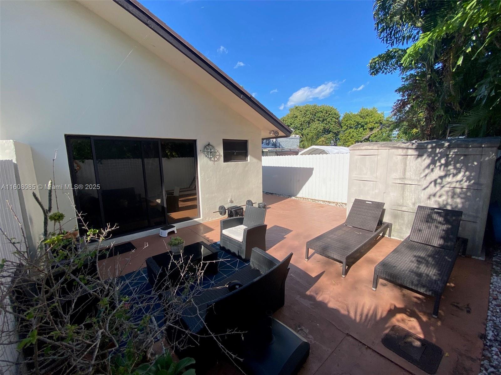 1632 Southwest 19th Terrace Miami, FL 33145 - Photo 16 of 16 a view of a patio with table and chairs with wooden floor and fence