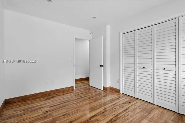 a view of empty room with wooden floor