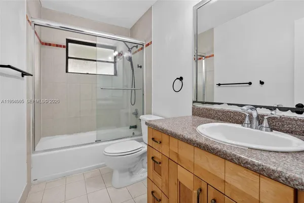 a bathroom with a granite countertop sink a toilet and shower