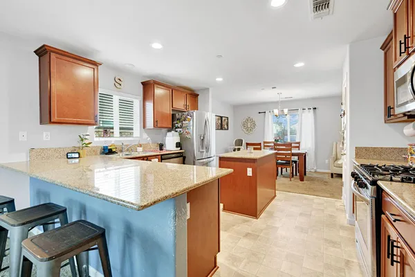 a large kitchen with kitchen island a sink stove and white cabinets