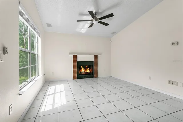 a view of an empty room with a fireplace and a window