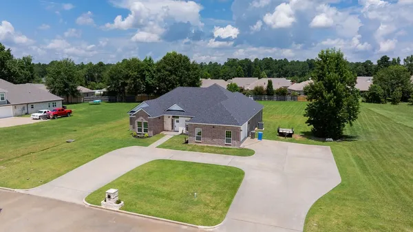 a view of a house with a big yard and large trees