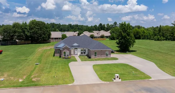 a view of a house with a big yard and a large tree