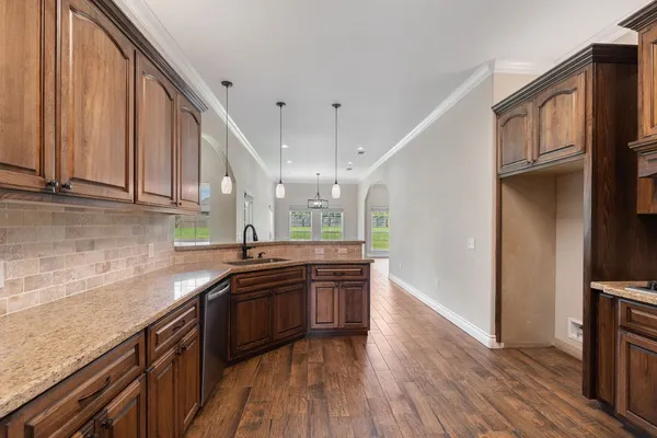 a view of a kitchen with a sink and wooden floor