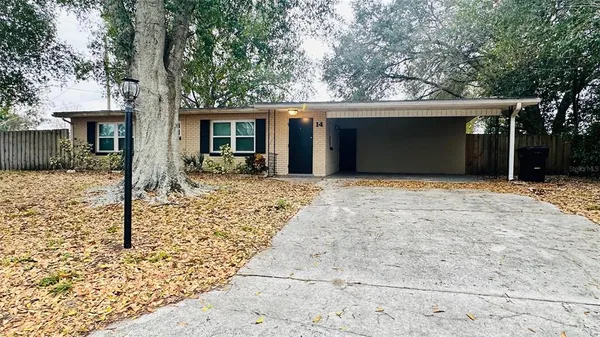 a front view of house with yard and trees in the background