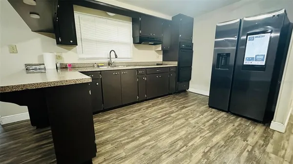 a kitchen with stainless steel appliances granite countertop a refrigerator and a sink