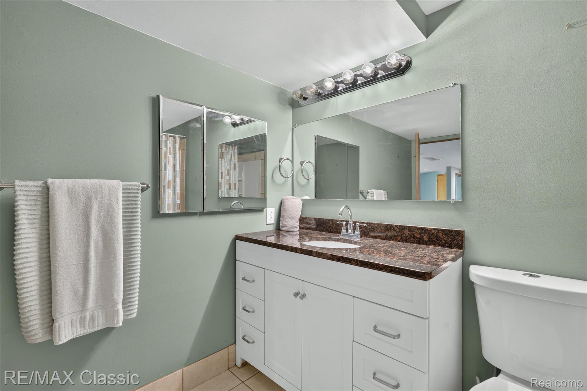 12189 Gage Road Holly, MI 48442 - Photo 45 of 69 Bathroom featuring a white vanity with a dark countertop, an integrated sink, and a chrome faucet