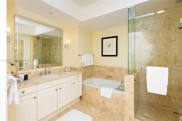 a spacious bathroom with a double vanity sink mirror and bathtub