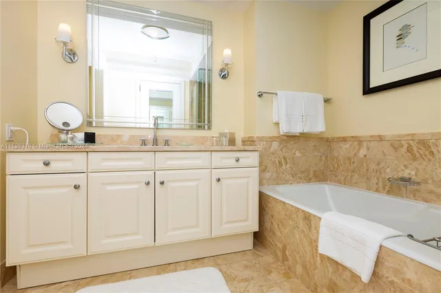 a spacious bathroom with a granite countertop sink mirror and bathtub