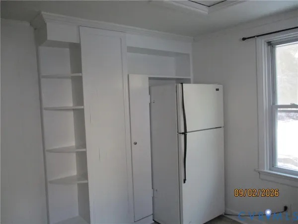 a white refrigerator freezer and a window in a room