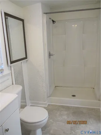 a bathroom with a toilet and a shower