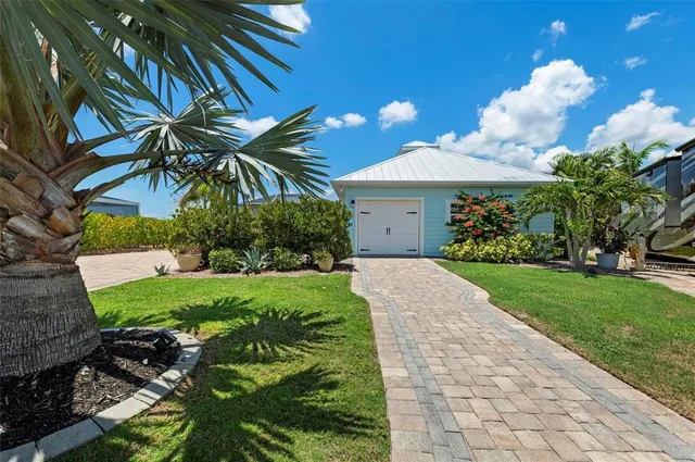 a front view of a house with a yard and potted plants