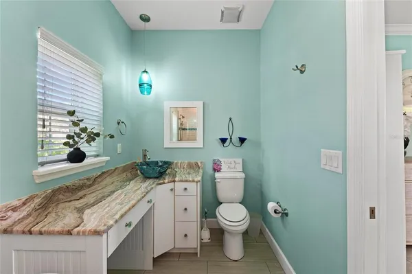 a bathroom with a granite countertop toilet sink and mirror