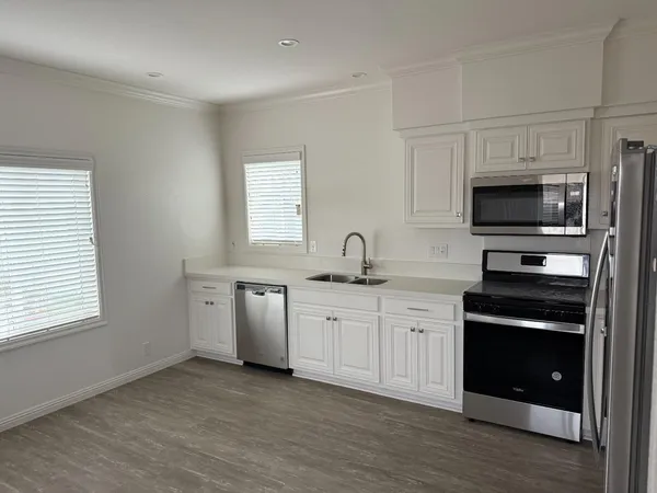 a kitchen with appliances a sink and cabinets