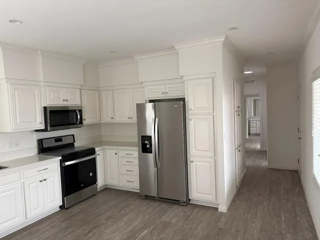 a kitchen with a refrigerator stove and wooden cabinets