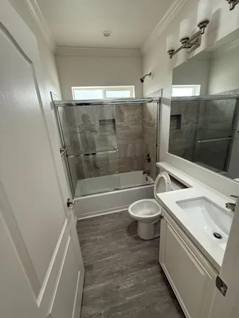 a bathroom with a sink a toilet and shower