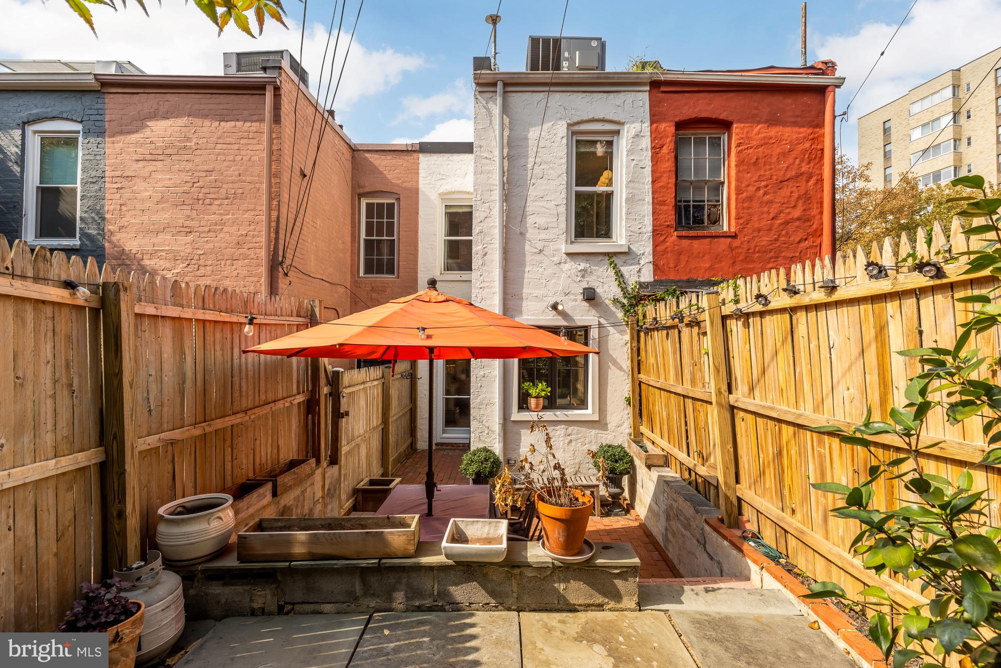 1652 Kalorama Road Northwest Washington, DC 20009 - Photo 9 of 17 a view of a patio with a table and chairs under an umbrella with wooden floor
