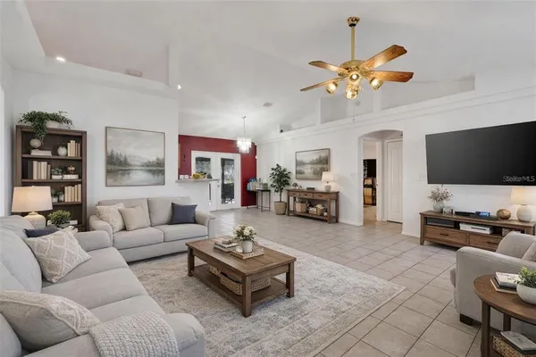 a living room with furniture kitchen view and a flat screen tv