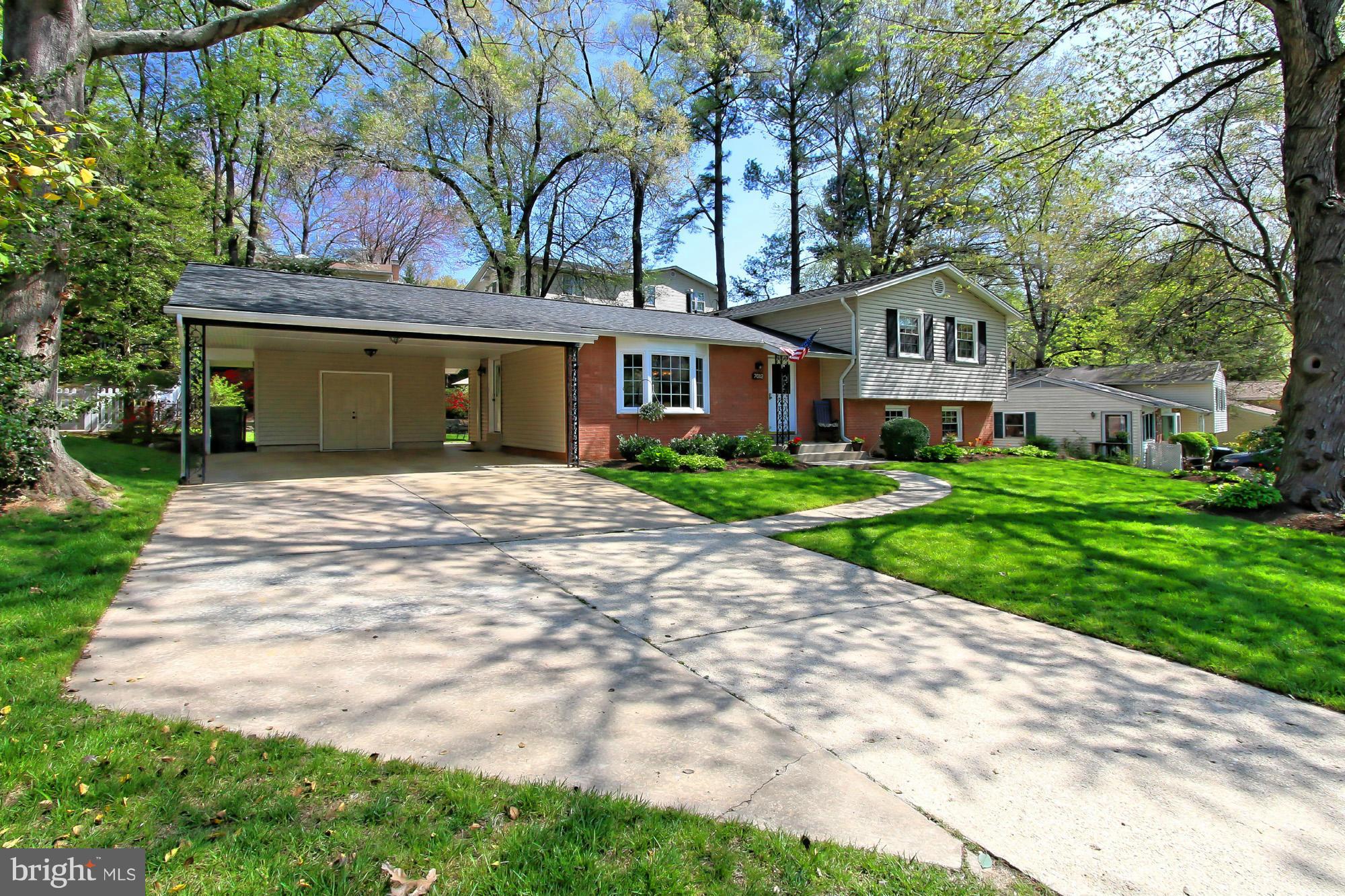 7012 Hadlow Drive Springfield, VA 22152 - Photo 3 of 30 a front view of a house with a garden and yard