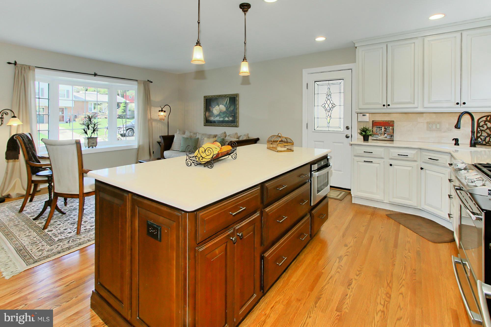 7012 Hadlow Drive Springfield, VA 22152 - Photo 10 of 30 a kitchen with a stove a refrigerator a sink dishwasher with a dining table and chairs with wooden floor