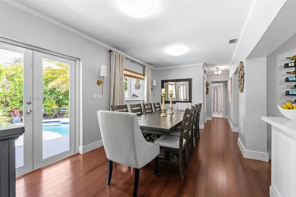 a kitchen with stainless steel appliances a refrigerator a stove a sink dishwasher and white cabinets with wooden floor