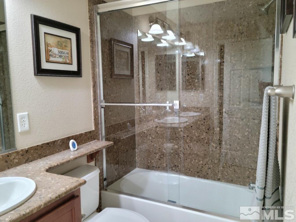 8950 Convair Way Reno, NV 89506 - Photo 11 of 26 a bathroom with a granite countertop sink a toilet and shower
