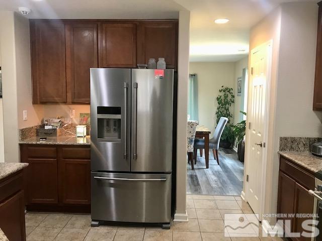 8950 Convair Way Reno, NV 89506 - Photo 7 of 26 a kitchen with stainless steel appliances granite countertop a refrigerator a stove a sink and a dining table with wooden floor